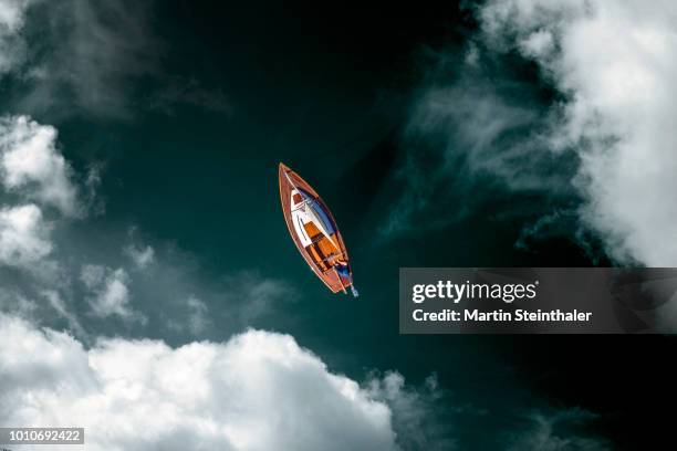 bemanntes segelboot - luftaufnahme mit wolken - boat on water stock-fotos und bilder