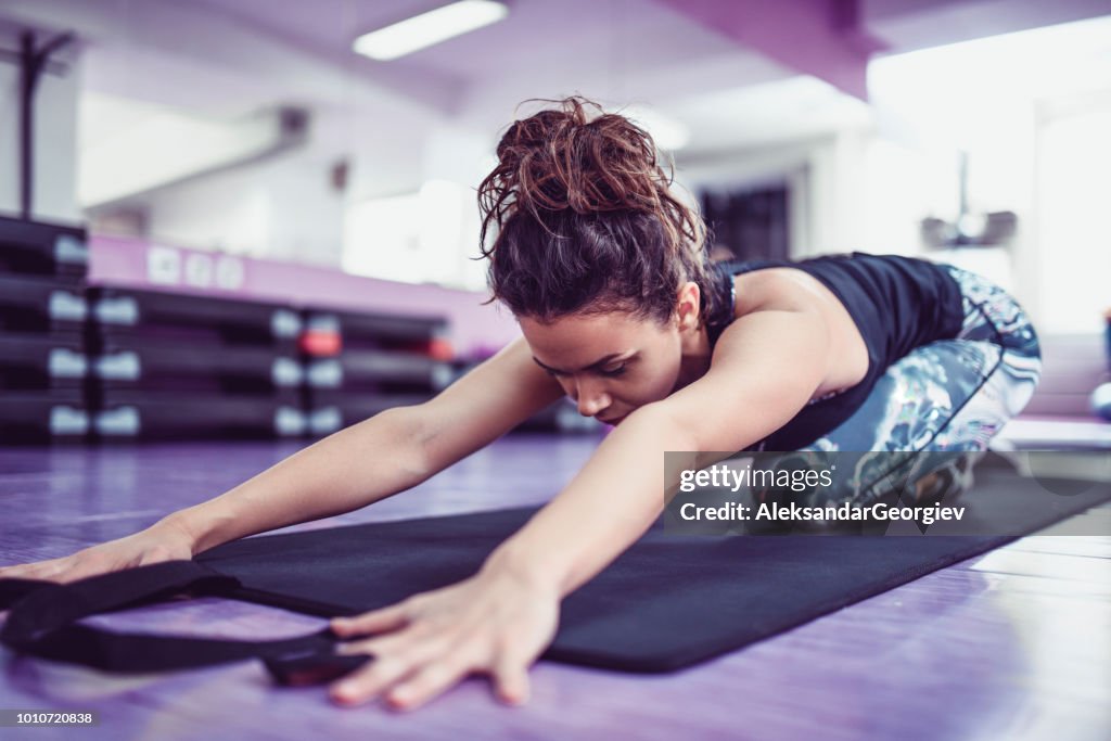 Athletic Female Stretching On Exercise Mat In Gym