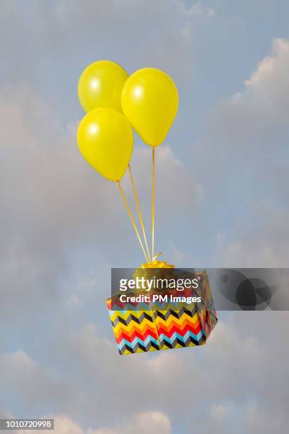 helium balloons carrying gift - balloon knot stock pictures, royalty-free photos & images