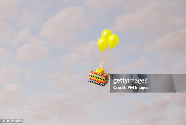 helium balloons carrying gift - balloon knot stock pictures, royalty-free photos & images