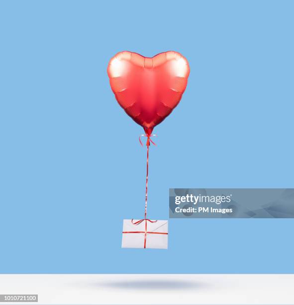 heart shaped balloon carrying love letter - balloon letters stock pictures, royalty-free photos & images