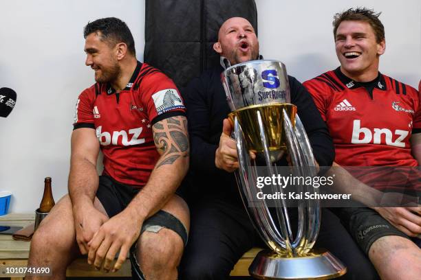 Codie Taylor, Assistant Coach Jason Ryan and Matt Todd of the Crusaders pose with the Super Rugby Trophy in their dressing room after their win in...