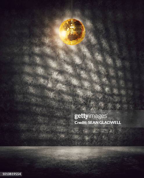 empty room with gold mirrored disco ball spinning - glitter ball stock-fotos und bilder