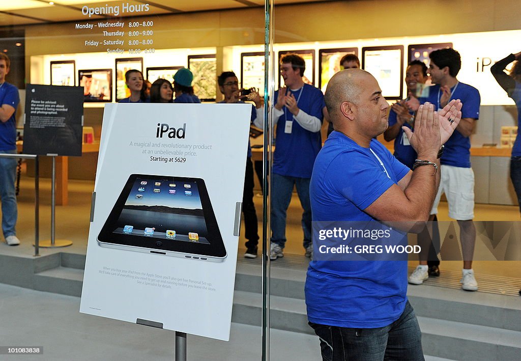 Staff members cheer inside Apple's flags