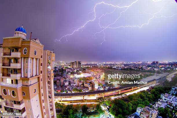 lightning strike over a modern indian city at night - gurgaon stock pictures, royalty-free photos & images