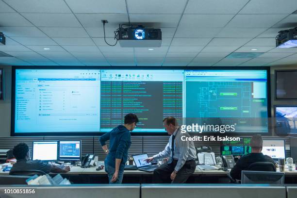 colleagues working together in server control room - medium group of people stockfoto's en -beelden