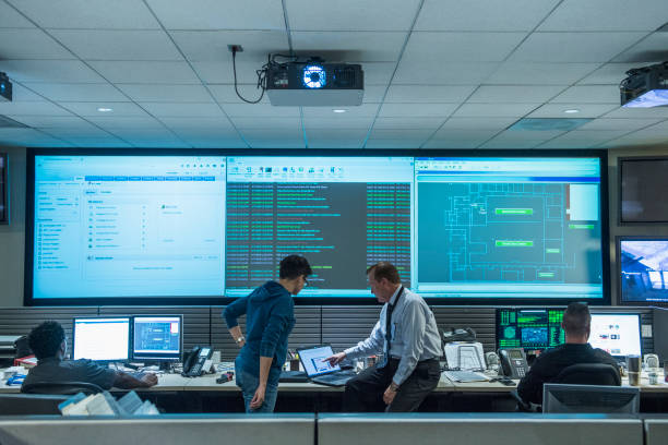 colleagues working together in server control room - security room screens stock pictures, royalty-free photos & images colleagues working together in server control room - security room screens stock pictures, royalty-free photos & images
