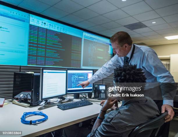 colleagues working together in server control room - sala de control fotografías e imágenes de stock