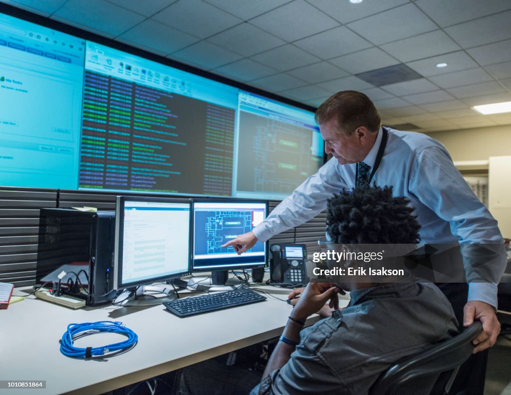 Colleagues working together in server control room