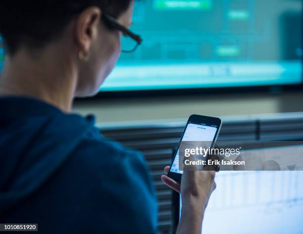 woman using smart phone in server control room - storage solutions stock pictures, royalty-free photos & images