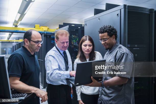 colleagues working together in server room - medium group of people stockfoto's en -beelden