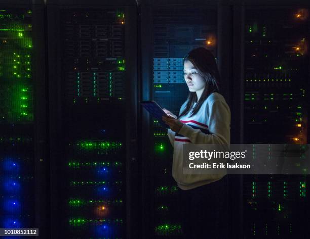 young woman working on digital tablet in server room - server professional stock-fotos und bilder