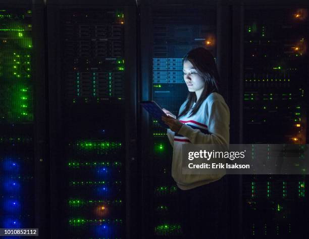 young woman working on digital tablet in server room - data management stock pictures, royalty-free photos & images