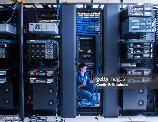 woman organizing cables in server room - data centre stock pictures, royalty-free photos & images
