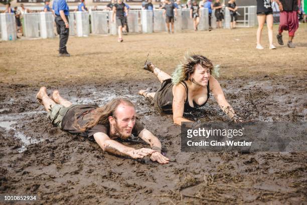 Festival visitors enjoy the mud and dirt during the Wacken Open Air festival on August 4, 2018 in Wacken, Germany. Wacken is a village in northern...