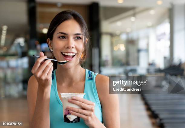 woman eating a healthy snack at the gym - calcio sport imagens e fotografias de stock