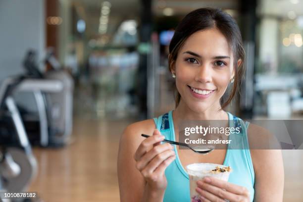 woman eating a healthy snack at the gym - yoghurt stock pictures, royalty-free photos & images