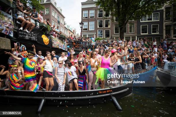 Spectators on the street and on boats watch Revellers dance at the traditional Canal Parade during Amsterdam Gay Pride on August 4, 2018 in...