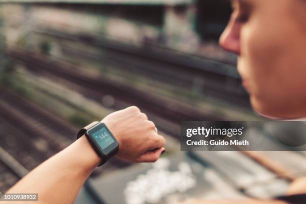 woman checking pulse after running. - joggerin stock-fotos und bilder