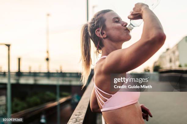 woman drinking after hard workout. - corpo normale foto e immagini stock