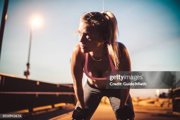 exhausted woman after fitness workout in the city. - beautiful woman body stockfoto's en -beelden