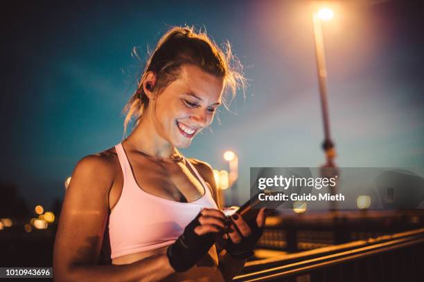 happy woman using smartphone after workout in city. - technology strength stock-fotos und bilder