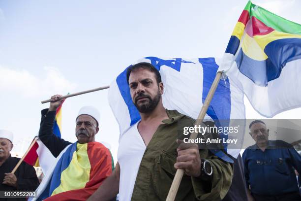 Man dressed with half an IDF uniform holds a Druze flag during a protest against Jewish state nation law in Rabin Square on August 4, 2018 in Tel...