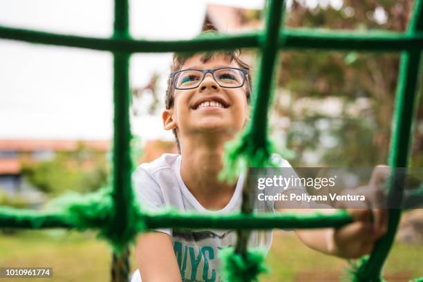 kleine junge klettergerüst seil - kind brille stock-fotos und bilder