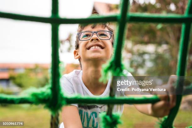 little boy climbing rope frame - jungle gym stock pictures, royalty-free photos & images