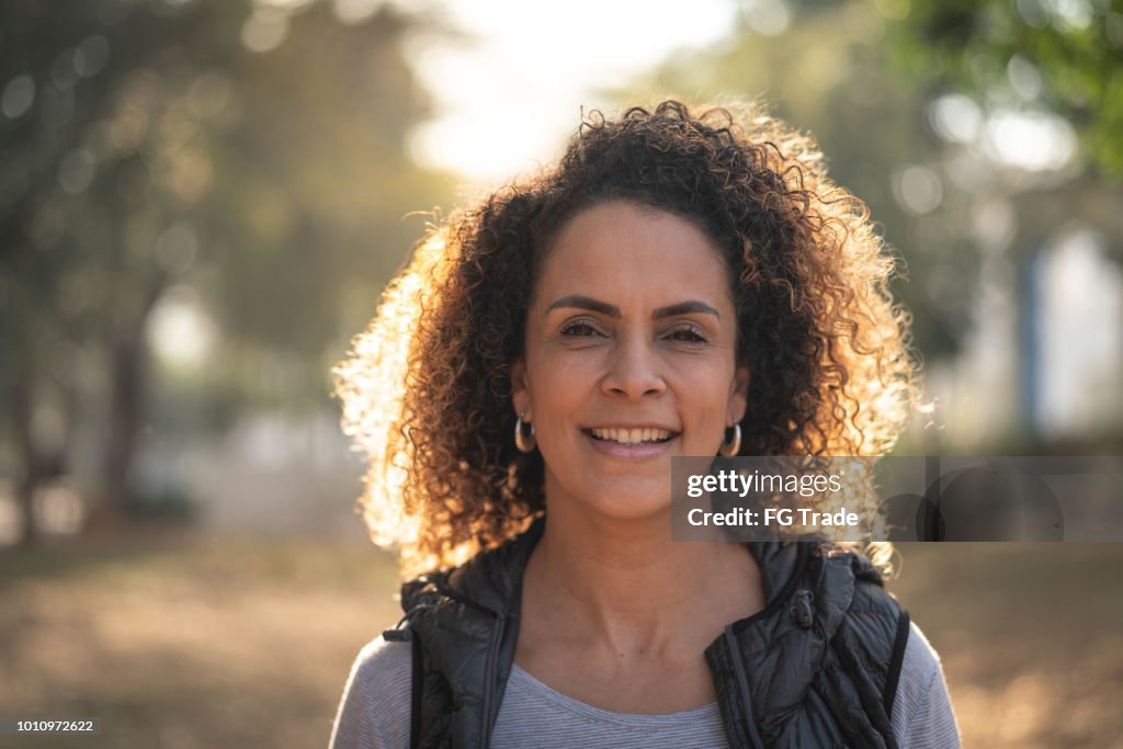 Mulher madura linda cabelo encaracolado olhando para a câmera