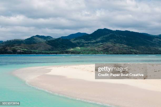 view of palawan beach with blue sky and clear water with mountains at the background - puerto princesa stock pictures, royalty-free photos & images