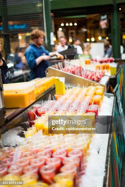 people selling fresh fruit smoothies and juices on stall at borough market, london, uk - juice bar stock pictures, royalty-free photos & images