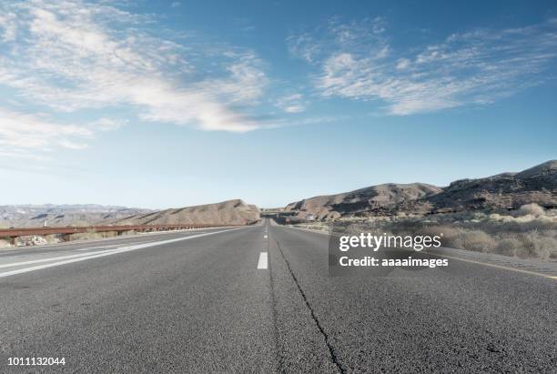 straight endless road through desert - empty road mountains stock pictures, royalty-free photos & images