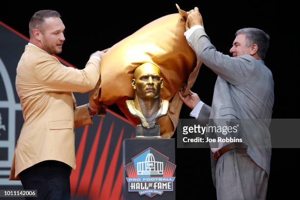 Brian Urlacher unveils his bust along with former coach Bob Babich during the 2018 NFL Hall of Fame Enshrinement Ceremony at Tom Benson Hall of Fame...