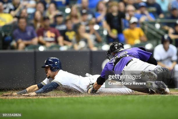Hernan Perez of the Milwaukee Brewers beats a tag at home by Chris Iannetta of the Colorado Rockies during the sixth inning of a game at Miller Park...