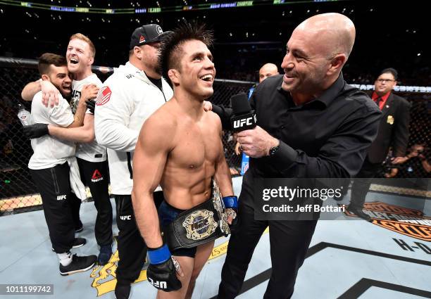 Henry Cejudo is interviewed by Joe Rogan after his split-decision victory over Demetrious Johnson in their UFC flyweight championship fight during...