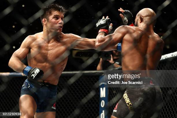 Henry Cejudo punches Demetrious Johnson in the third round of the UFC Flyweight Title Bout during UFC 227 at Staples Center on August 4, 2018 in Los...