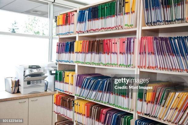 a group of colourful file folders in a dental office. - medical record stock pictures, royalty-free photos & images