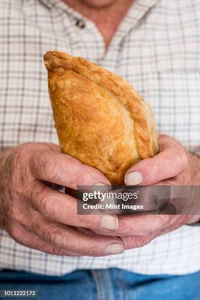 a man holding a fresh homemade pasty with a crimped edge, a regional speciality - folhado cornish imagens e fotografias de stock