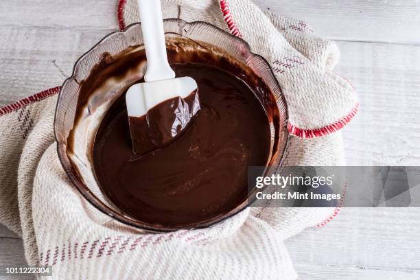 a bowl of chocolate brownie ingredients being stirred by a spatula. - brownie stock pictures, royalty-free photos & images