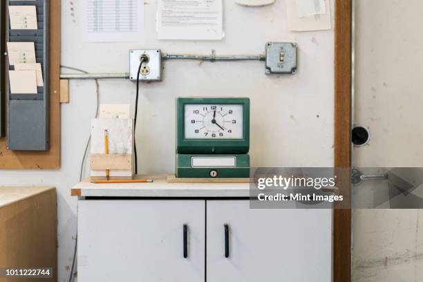 timeclock used to check in employees in a woodworking factory. - stechuhr stock-fotos und bilder