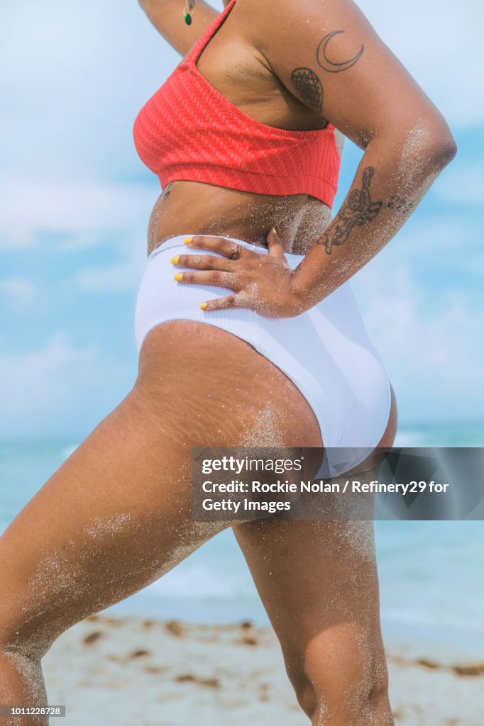 Young confident woman standing on the beach