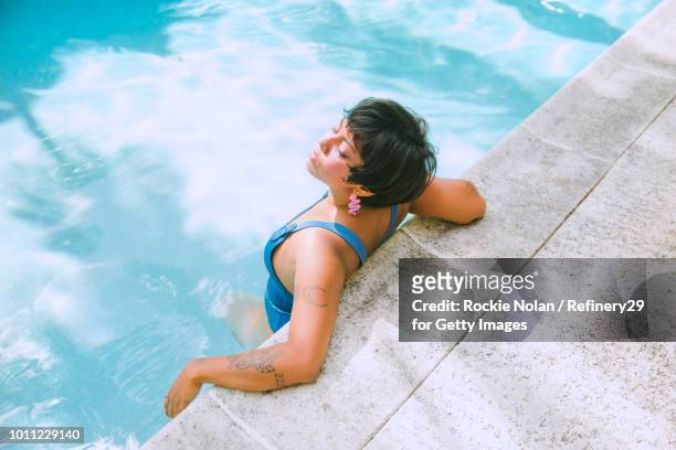 Young confident woman relaxing in a pool