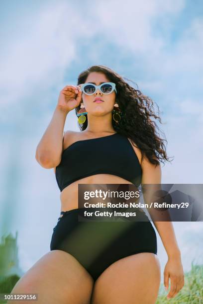 young confident woman standing on the beach - body positivity stock-fotos und bilder