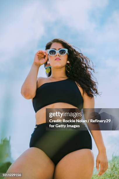 young confident woman standing on the beach - body positive stockfoto's en -beelden