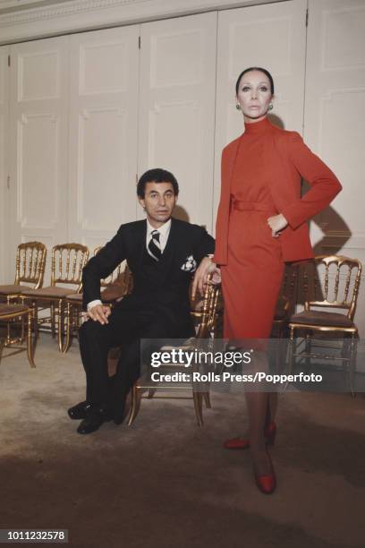 American fashion designer Gustave Tassell pictured with a female model in the showroom of Norman Norell in New York on 14th November 1972. Gustave...