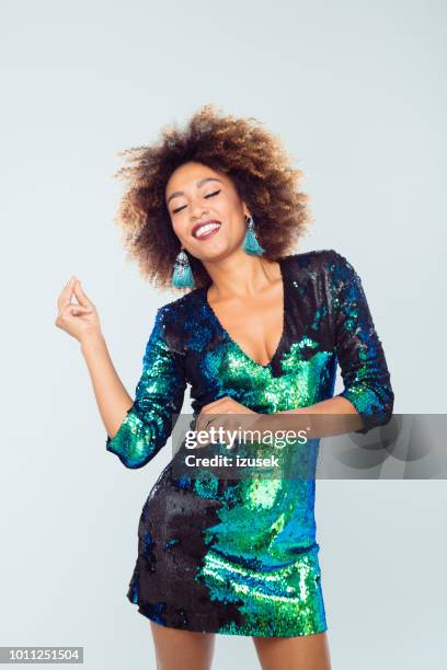 schönes afro mädchen tanzen in pailletten-kleid - paillettenkleid stock-fotos und bilder