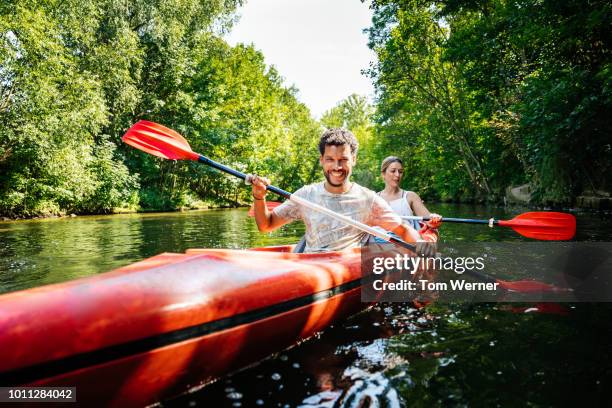 couple paddling together in kayak - kayak fotografías e imágenes de stock