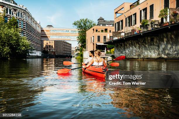 couple paddling down inner city canals - leipzig saxony stockfoto's en -beelden