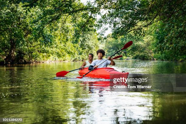 young couple exploring river in kayak - kayaking couple stock pictures, royalty-free photos & images